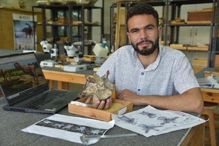 Study leader Belal Salem of Ohio University and the Mansoura University Vertebrate Paleontology Center (MUVP) examines the roughly 98-million-year-old abelisaurid theropod neck vertebra discovered from the Bahariya Oasis that forms the basis of the new study. Credit: Ohio University