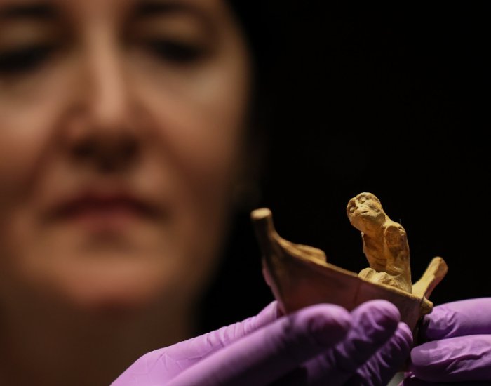 Izmir Archeology Museum ᴀssistant manager Elif Erginer shows the 2,400-year-old statuette depicting the ferryman of the ᴅᴇᴀᴅ, Charon, Izmir, Türkiye, Nov. 15, 2022. (AA PH๏τo)