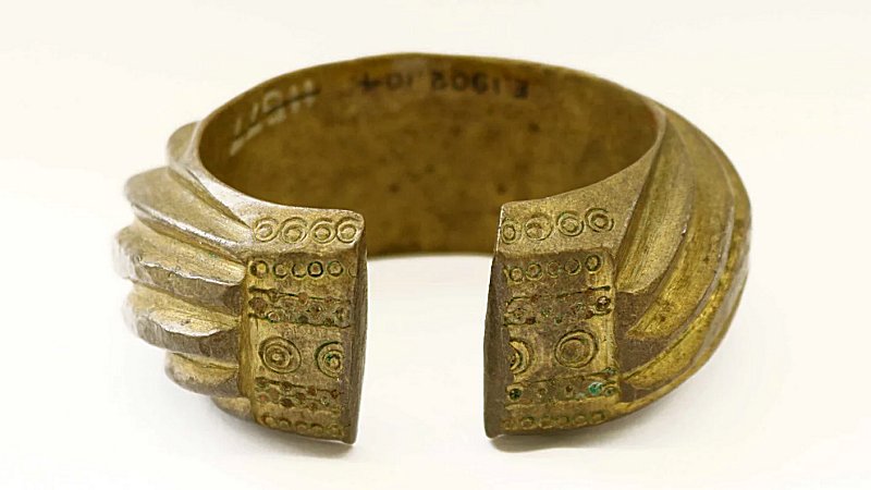 A brᴀss penannular bracelet decorated with heavy slanting bands.